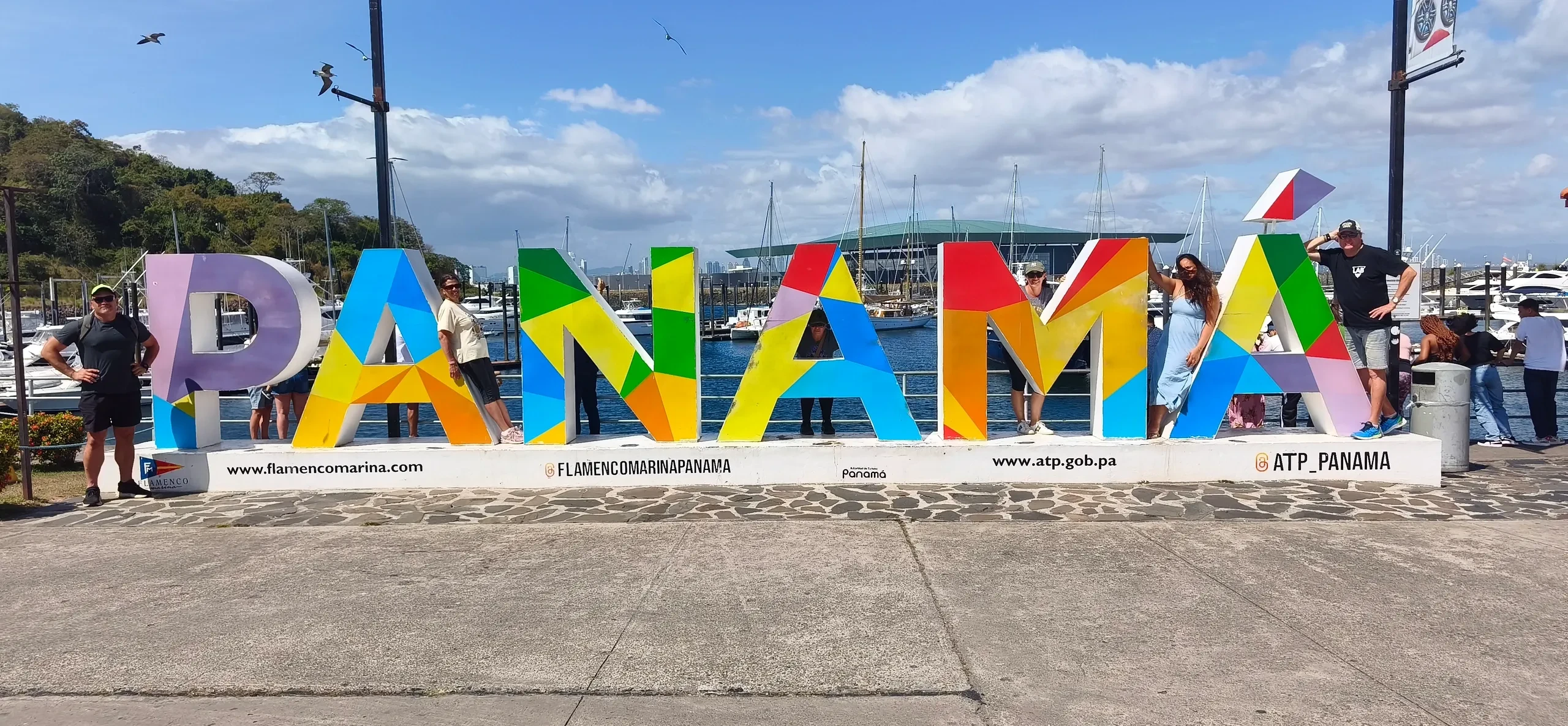 Group posing at the colorful PANAMÁ sign at Flamenco Marina